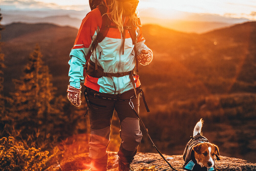 Kvinne og hund på tur i fjellet ikledd Alfa utstyr
